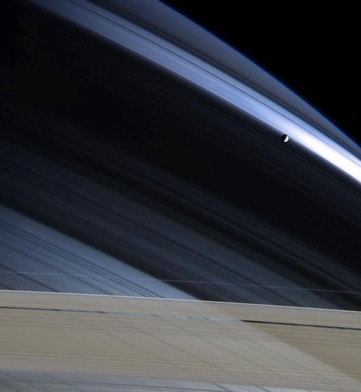 Foto della Cassini dell'emisfero nord bluastro; si vedono gli anelli, grigi, e la luna Mimas.